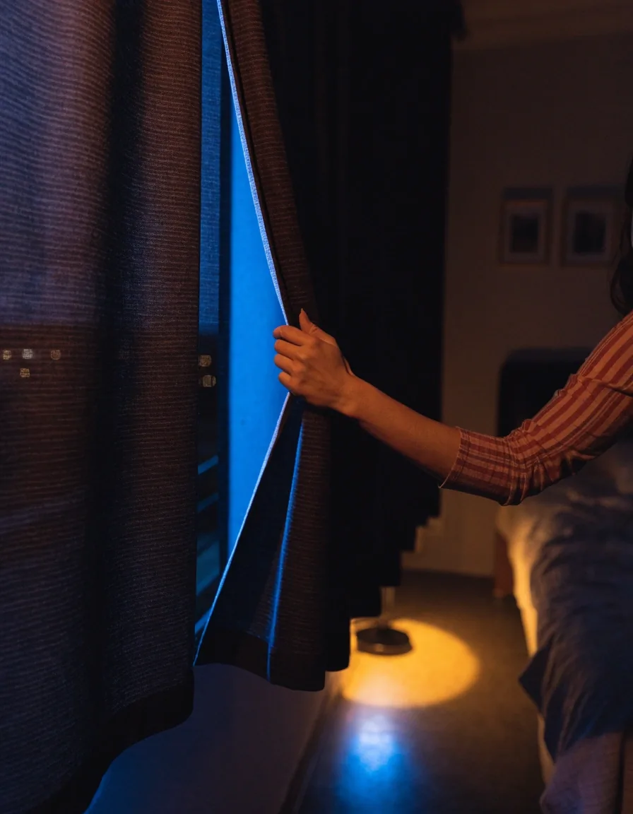Borde de una cortina blackout roller a medio bajar con luz de ventana sobre la tela